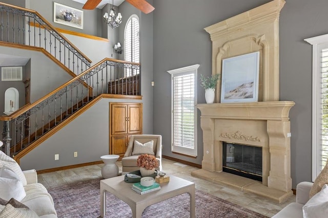 4719 W Two Lakes Ave, Norman, OK 73072 - living room featuring a high ceiling, stairway, healthy amount of natural light, a chandelier, and a premium fireplace