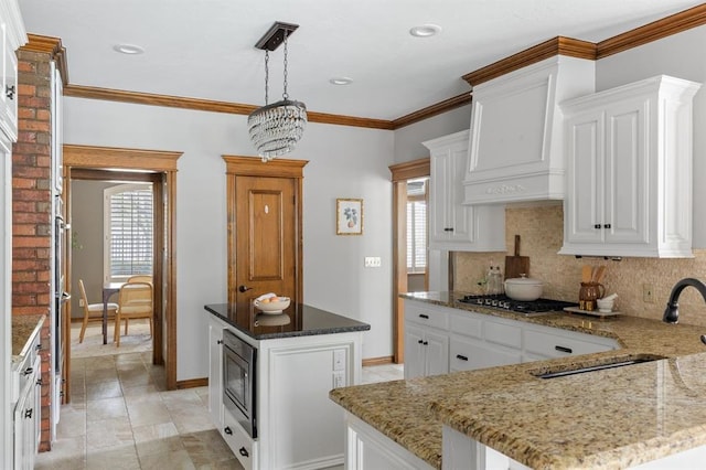 4719 W Two Lakes Ave, Norman, OK 73072 - kitchen with stainless steel appliances, backsplash, light stone counters, white cabinets, and ornamental molding