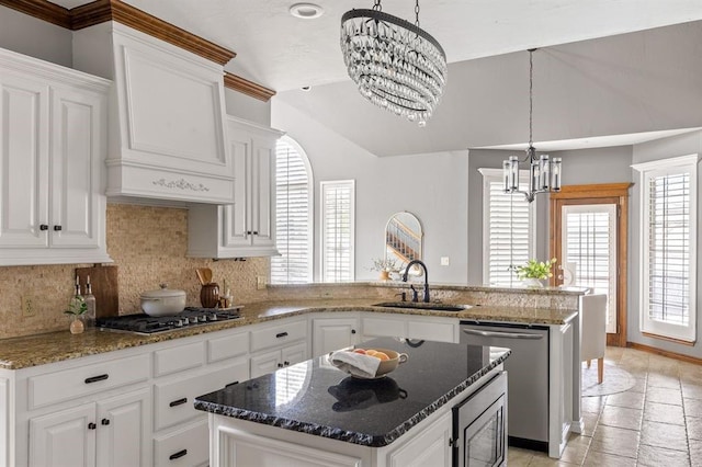4719 W Two Lakes Ave, Norman, OK 73072 - kitchen with a chandelier, appliances with stainless steel finishes, a peninsula, decorative backsplash, and vaulted ceiling