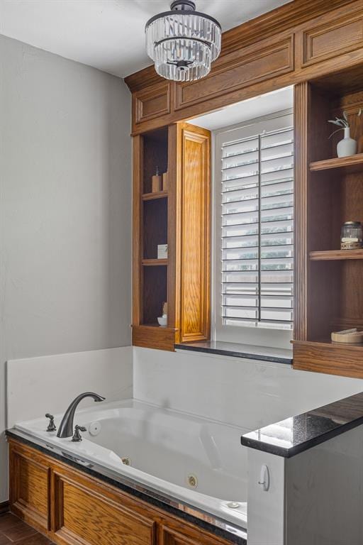 4719 W Two Lakes Ave, Norman, OK 73072 - bathroom featuring a whirlpool tub and a chandelier