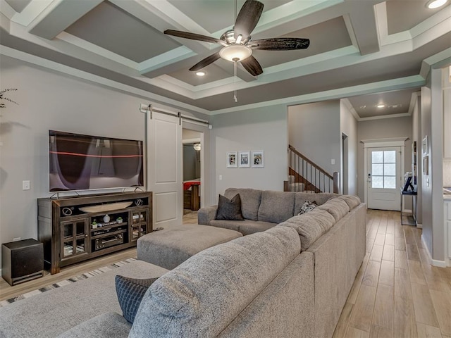 10101 NW 137th St, Yukon, OK 73099 - living area featuring a barn door, crown molding, ceiling fan, coffered ceiling, and light wood-style flooring
