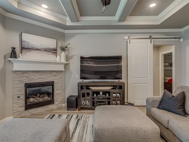 10101 NW 137th St, Yukon, OK 73099 - living room featuring a barn door, wood finished floors, a glass covered fireplace, recessed lighting, and beam ceiling