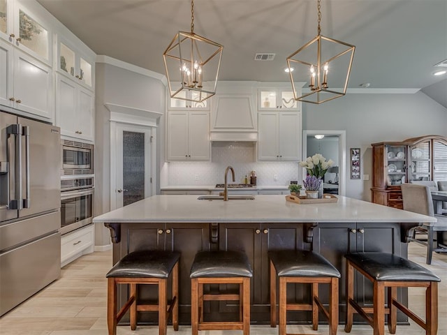 10101 NW 137th St, Yukon, OK 73099 - kitchen with stainless steel appliances, a chandelier, custom range hood, backsplash, and lofted ceiling
