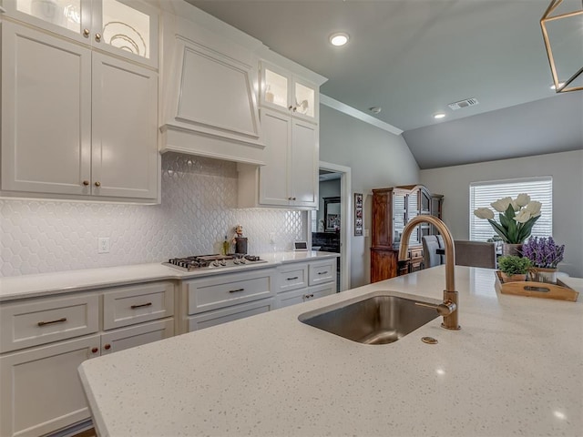 10101 NW 137th St, Yukon, OK 73099 - kitchen featuring stainless steel gas stovetop, white cabinetry, decorative backsplash, light stone countertops, and custom exhaust hood