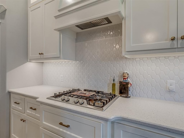 10101 NW 137th St, Yukon, OK 73099 - kitchen with stainless steel gas stovetop, premium range hood, backsplash, and white cabinets