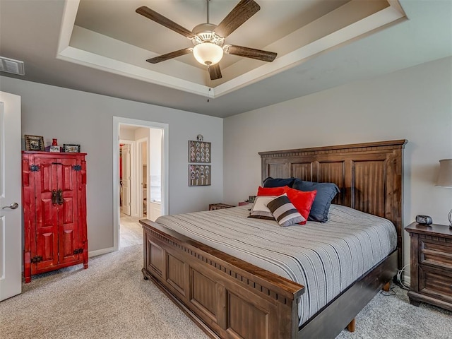 10101 NW 137th St, Yukon, OK 73099 - bedroom with a raised ceiling, light carpet, a ceiling fan, and ensuite bath