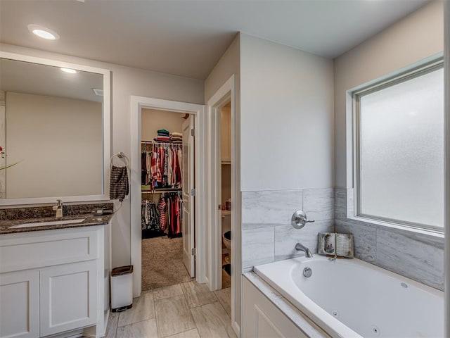 10101 NW 137th St, Yukon, OK 73099 - bathroom with a whirlpool tub, vanity, a spacious closet, and marble finish flooring