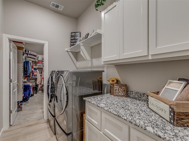 10101 NW 137th St, Yukon, OK 73099 - laundry area featuring washing machine and clothes dryer, cabinet space, and light wood-type flooring