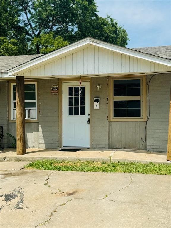 427 SE 17th St, Oklahoma City, OK 73129 - property entrance with brick siding, a shingled roof, and covered porch