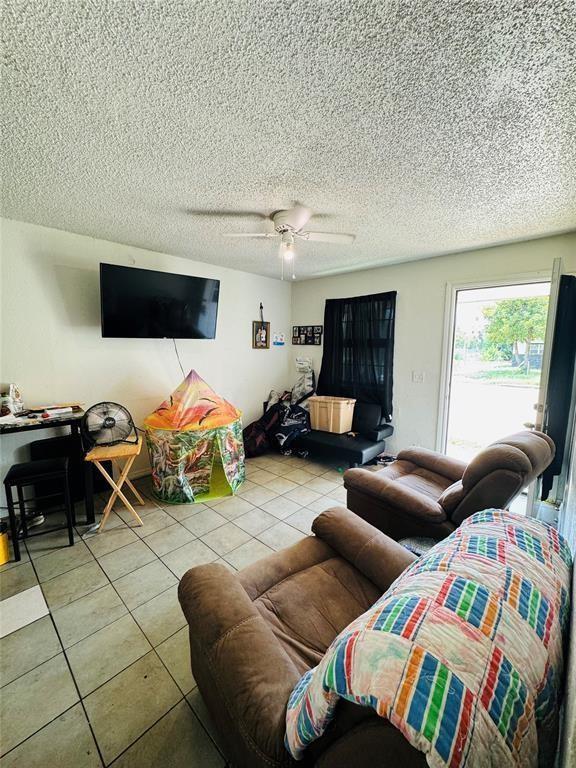 427 SE 17th St, Oklahoma City, OK 73129 - living area featuring tile patterned flooring, ceiling fan, and a textured ceiling