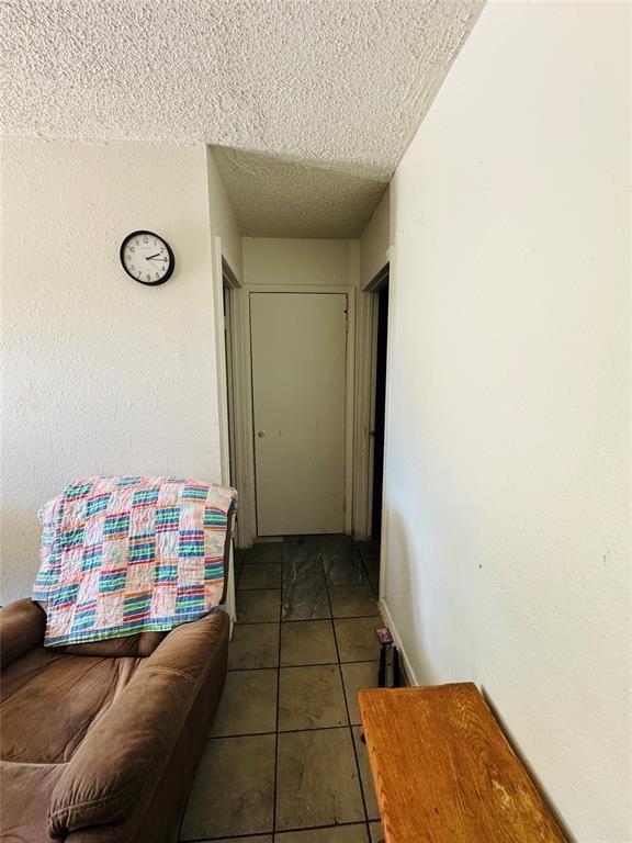 427 SE 17th St, Oklahoma City, OK 73129 - corridor featuring a textured ceiling and tile patterned flooring