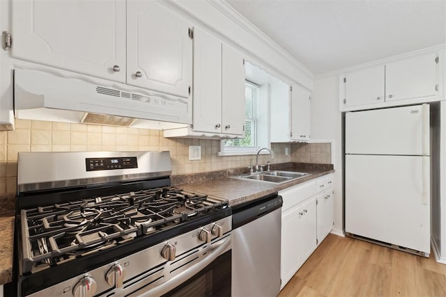 4112 SE 22nd St, Del City, OK 73115 - kitchen featuring appliances with stainless steel finishes, under cabinet range hood, white cabinetry, backsplash, and ornamental molding