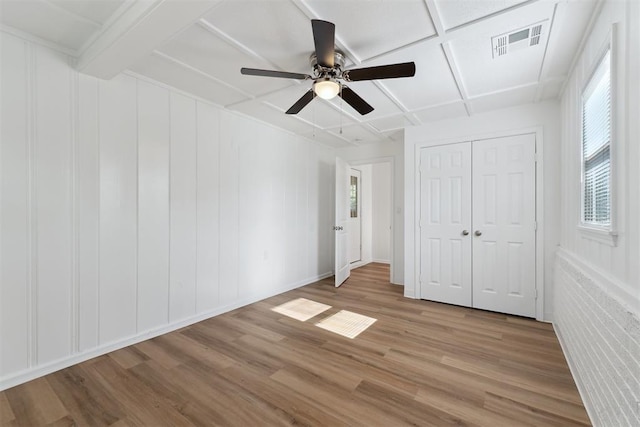 4112 SE 22nd St, Del City, OK 73115 - unfurnished bedroom featuring multiple windows, wood finished floors, ceiling fan, a closet, and coffered ceiling