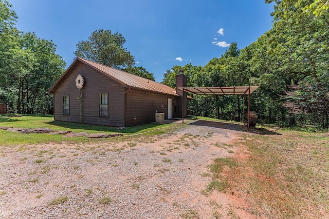 22797 N Henney Rd, Luther, OK 73054 - view of side of home featuring driveway, a detached carport, a pergola, a metal roof, and a yard