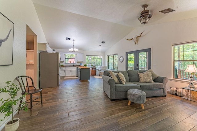 22797 N Henney Rd, Luther, OK 73054 - living room featuring a chandelier, dark wood-style floors, vaulted ceiling, a ceiling fan, and french doors
