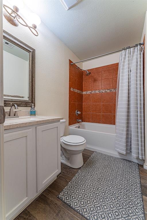 22797 N Henney Rd, Luther, OK 73054 - full bath featuring shower / bath combo with shower curtain, vanity, and wood finished floors