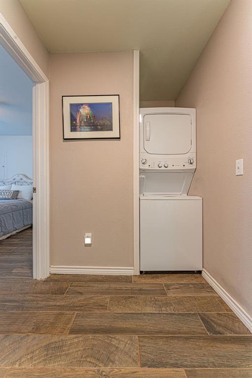 22797 N Henney Rd, Luther, OK 73054 - washroom featuring stacked washer / drying machine and dark wood finished floors