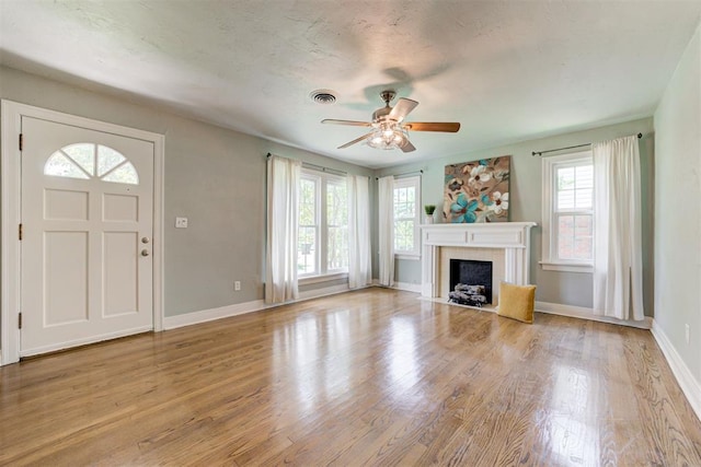 701 NW 46th St, Oklahoma City, OK 73118 - unfurnished living room with a ceiling fan, wood finished floors, and a fireplace with flush hearth