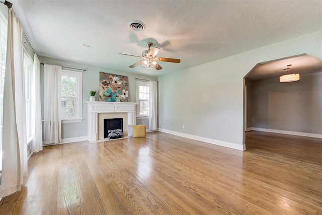 701 NW 46th St, Oklahoma City, OK 73118 - unfurnished living room with wood finished floors, a ceiling fan, healthy amount of natural light, and a fireplace with flush hearth