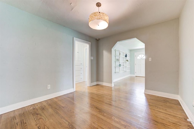 701 NW 46th St, Oklahoma City, OK 73118 - empty room with arched walkways and light wood-style floors