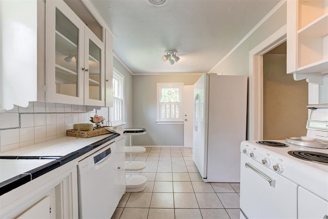 701 NW 46th St, Oklahoma City, OK 73118 - kitchen with white appliances, glass insert cabinets, light countertops, light tile patterned floors, and ornamental molding