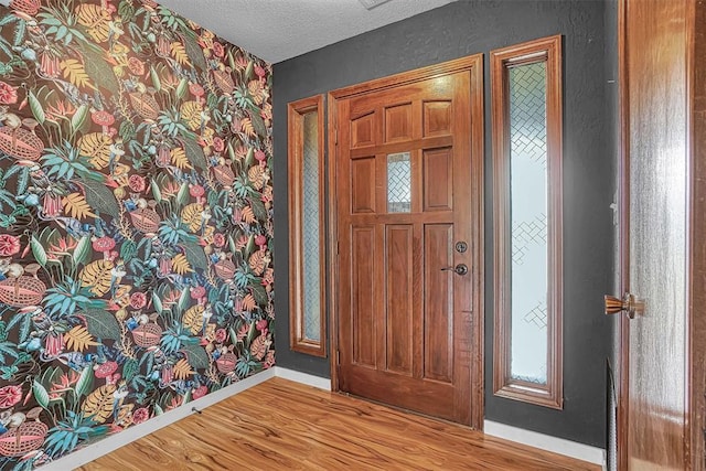 3208 Quail Cir, Altus, OK 73521 - foyer entrance featuring wood finished floors, a textured ceiling, and wallpapered walls