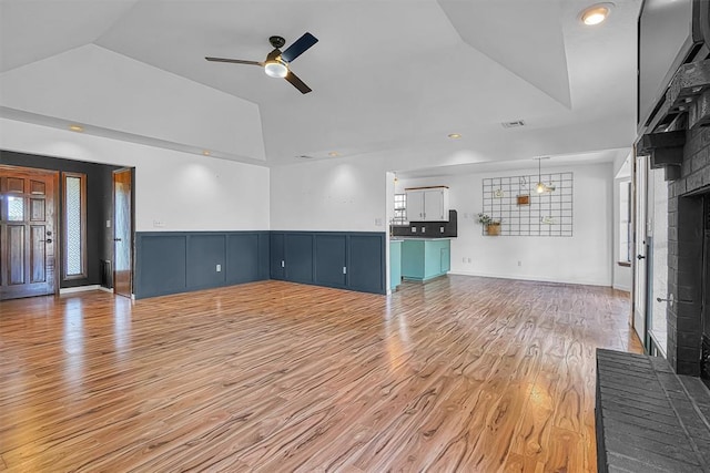 3208 Quail Cir, Altus, OK 73521 - unfurnished living room with vaulted ceiling, ceiling fan, light wood-style floors, and a brick fireplace