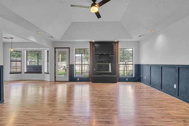 3208 Quail Cir, Altus, OK 73521 - unfurnished living room featuring a ceiling fan, a fireplace, wood finished floors, lofted ceiling, and a tray ceiling