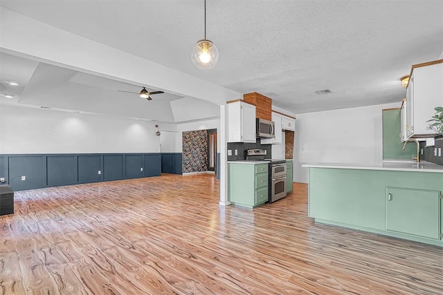 3208 Quail Cir, Altus, OK 73521 - kitchen featuring appliances with stainless steel finishes, green cabinetry, light wood-type flooring, open floor plan, and light countertops