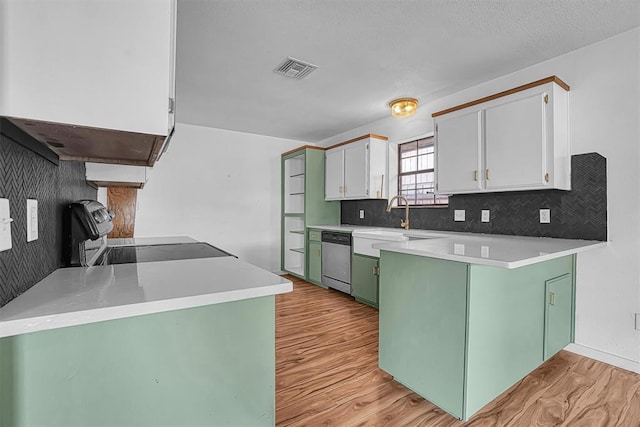 3208 Quail Cir, Altus, OK 73521 - kitchen with green cabinetry, light wood-type flooring, decorative backsplash, dishwasher, and a peninsula