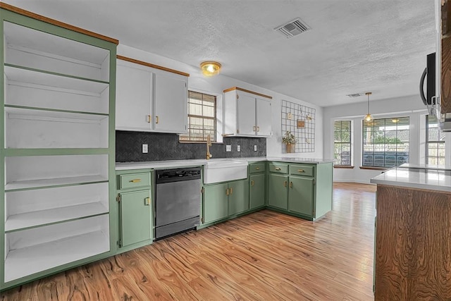 3208 Quail Cir, Altus, OK 73521 - kitchen featuring dishwasher, green cabinetry, light wood finished floors, a peninsula, and a textured ceiling