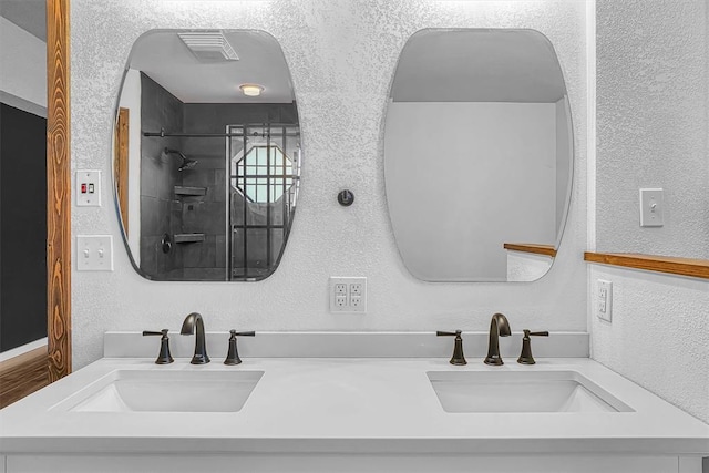 3208 Quail Cir, Altus, OK 73521 - full bath with double vanity, a textured wall, and a shower