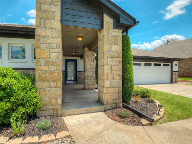 3903 Painted Bird Ln, Norman, OK 73071 - doorway to property featuring stone siding, a garage, and concrete driveway