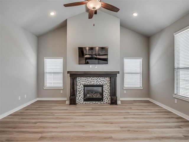3903 Painted Bird Ln, Norman, OK 73071 - unfurnished living room featuring lofted ceiling, ceiling fan, a tile fireplace, wood finished floors, and recessed lighting