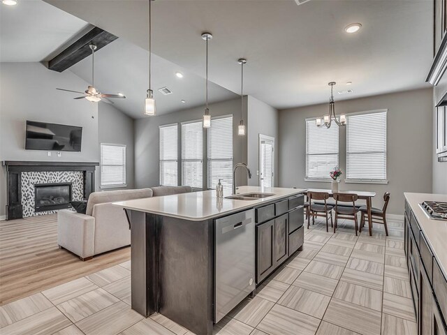 3903 Painted Bird Ln, Norman, OK 73071 - kitchen with appliances with stainless steel finishes, a tiled fireplace, a chandelier, recessed lighting, and light countertops