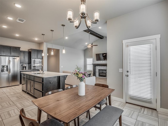 3903 Painted Bird Ln, Norman, OK 73071 - dining room with a stone fireplace, a ceiling fan, a chandelier, lofted ceiling, and recessed lighting
