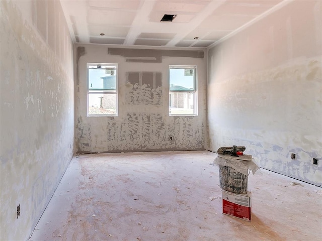 5701 NW 154th Ter, Edmond, OK 73013 - empty room featuring plenty of natural light, concrete flooring, coffered ceiling, and beamed ceiling