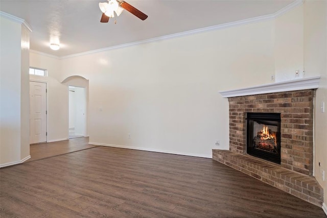 11829 NW 133rd St, Piedmont, OK 73078 - unfurnished living room with ceiling fan, crown molding, wood finished floors, a fireplace, and arched walkways