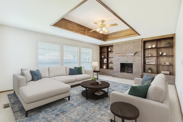 8317 NW 105th St, Oklahoma City, OK 73162 - living area with ceiling fan, a fireplace, built in shelves, carpet, and a tray ceiling
