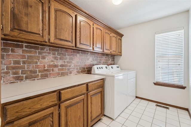 8317 NW 105th St, Oklahoma City, OK 73162 - laundry room with washing machine and dryer, cabinet space, and light tile patterned floors