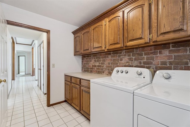 8317 NW 105th St, Oklahoma City, OK 73162 - laundry area with washer and clothes dryer, cabinet space, and light tile patterned floors
