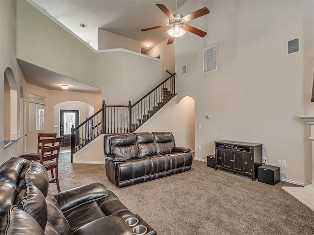 2313 NW 154th St, Edmond, OK 73013 - carpeted living area with arched walkways, stairway, ceiling fan, and a high ceiling