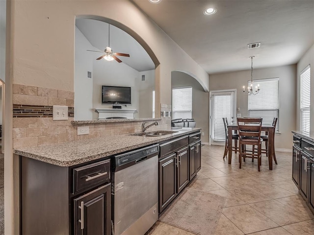 2313 NW 154th St, Edmond, OK 73013 - kitchen featuring stainless steel dishwasher, arched walkways, a ceiling fan, light stone counters, and decorative backsplash