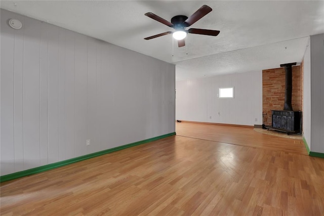 4012 SE 25th St, Del City, OK 73115 - unfurnished living room with a wood stove, wood finished floors, and a ceiling fan