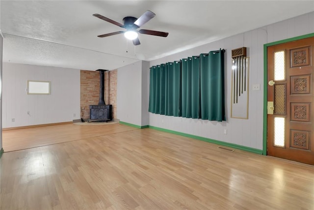 4012 SE 25th St, Del City, OK 73115 - unfurnished living room with a wood stove, ceiling fan, and wood finished floors