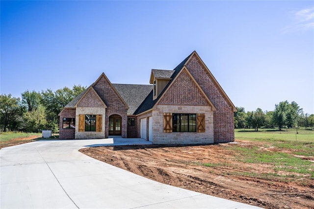 3124 Red Ridge Dr, Blanchard, OK 73010 - french provincial home with driveway, an attached garage, stone siding, and brick siding