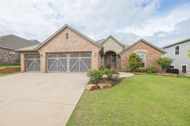 6301 Oxnard St, Edmond, OK 73034 - french country inspired facade featuring brick siding, an attached garage, concrete driveway, and a front lawn