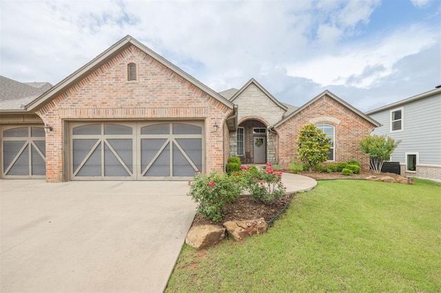 6301 Oxnard St, Edmond, OK 73034 - french provincial home with brick siding, a front yard, a garage, and driveway