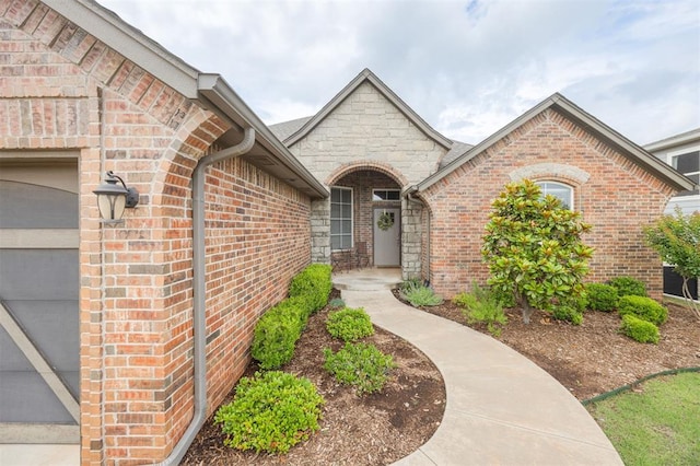 6301 Oxnard St, Edmond, OK 73034 - property entrance featuring brick siding, stone siding, and an attached garage