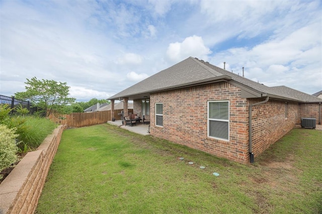 6301 Oxnard St, Edmond, OK 73034 - back of house with brick siding, a patio, a fenced backyard, and roof with shingles